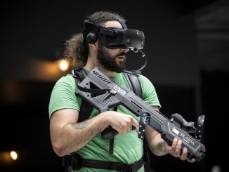 Homme équipé d’un casque VR et d’un fusil avec un sac à dos