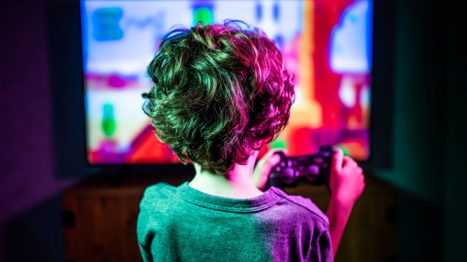 Devant son moniteur, ce jeune garçon dyslexique découvre les bienfaits des jeux vidéo.