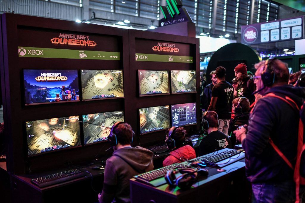 Un moniteur multiécrans sur lequel des compétiteurs e-sport disputent des parties de Minecraft Dungeons.