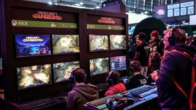 Un moniteur multiécrans sur lequel des compétiteurs e-sport disputent des parties de Minecraft Dungeons.