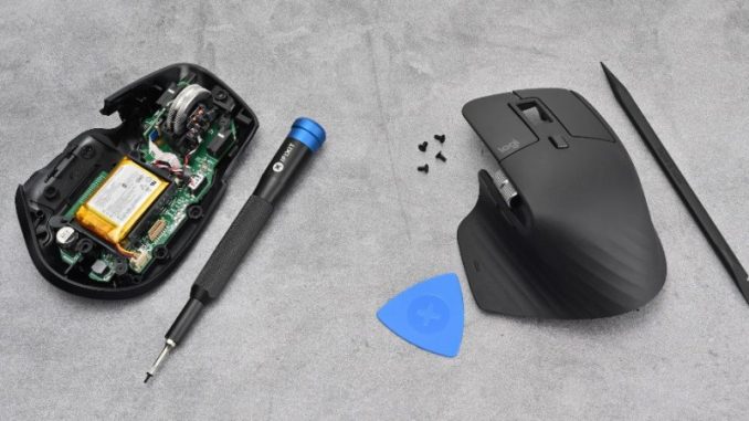 Une souris Logitech avec le capot ouvert et des matériels de réparation iFixit.