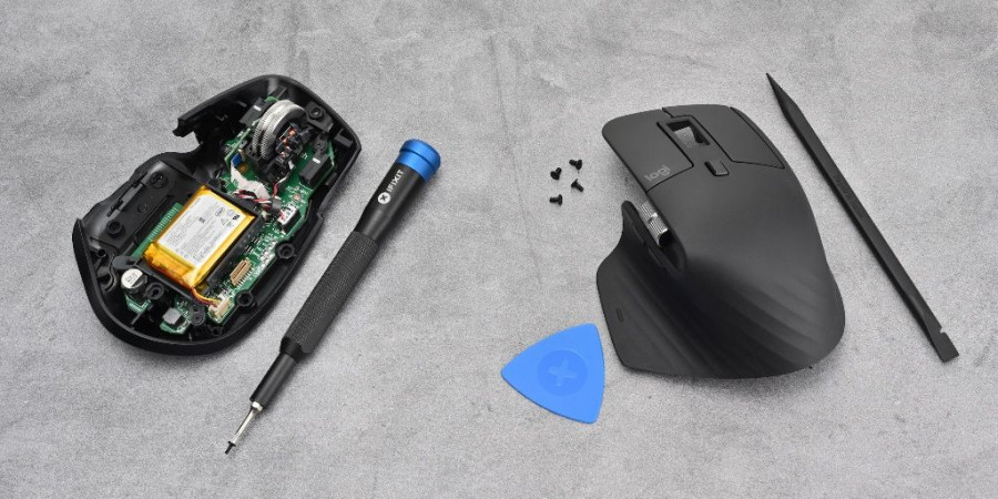 Une souris Logitech avec le capot ouvert et des matériels de réparation iFixit.