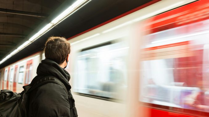 Un homme dans le métro avec un sac à dos avec un design semblable à l’Archer ErgoAir BP3800 d’ASUS ROG.