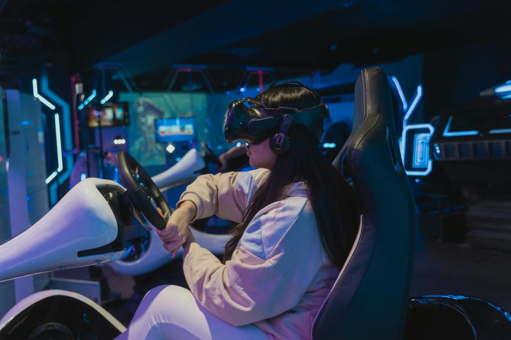 Une jeune femme en train de tester un volant, un parmi les accessoires développés par le pôle racing de NACON.