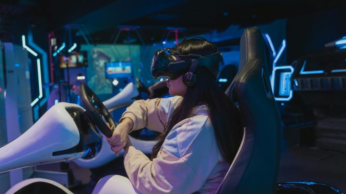 Une jeune femme en train de tester un volant, un parmi les accessoires développés par le pôle racing de NACON.