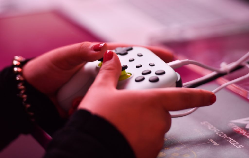 Crise des refugies : mains d’une femme tenant une manette de jeux video