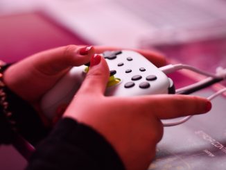 Crise des refugies : mains d’une femme tenant une manette de jeux video