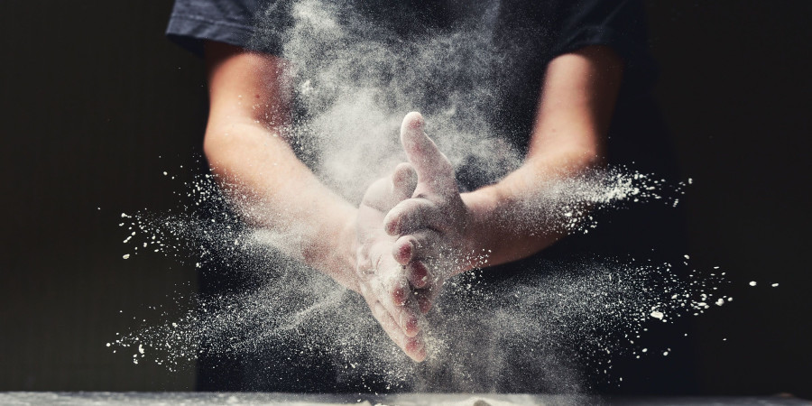 Un Français manipulant de la farine, s’apprêtant à faire de la cuisine et de la pâtisserie.