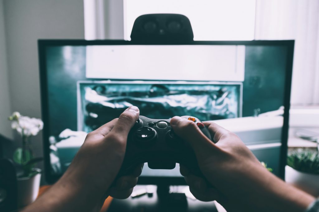 Une personne qui tient une manette de jeu video devant la television