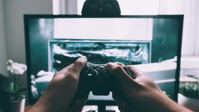 Une personne qui tient une manette de jeu video devant la television