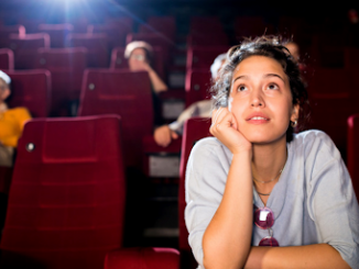 Une femme regardant un film dans une salle de cinéma