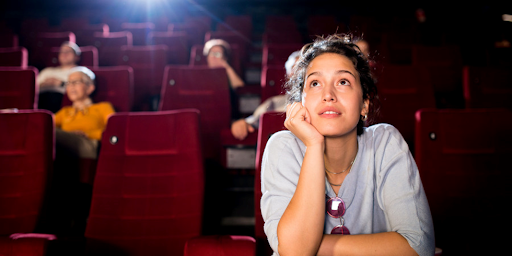 Une femme regardant un film dans une salle de cinéma