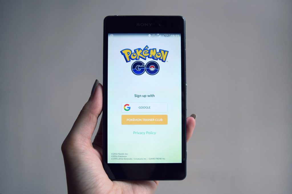 Une jeune adolescente tenant son smartphone, consciente des avantages du Pokémon GO.