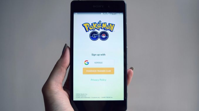 Une jeune adolescente tenant son smartphone, consciente des avantages du Pokémon GO.