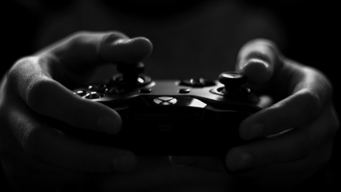 Main d’une personne tenant une manette de jeu