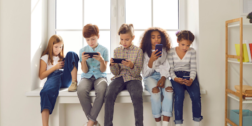 Enfants de 11-12 ans jouant sur leurs smartphones, privilégiant réseaux sociaux et jeux en ligne