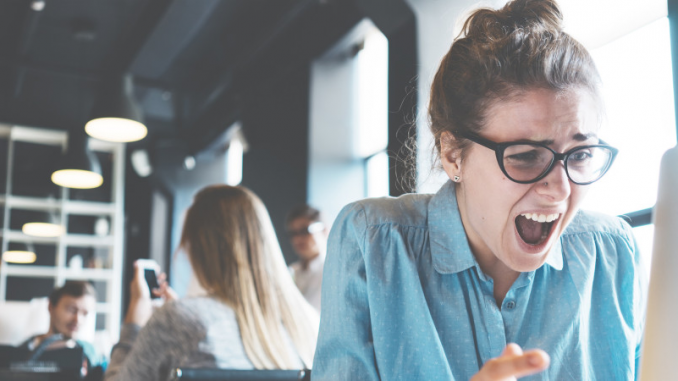 Une femme qui montre des signes de stress en utilisant son ordinateur.