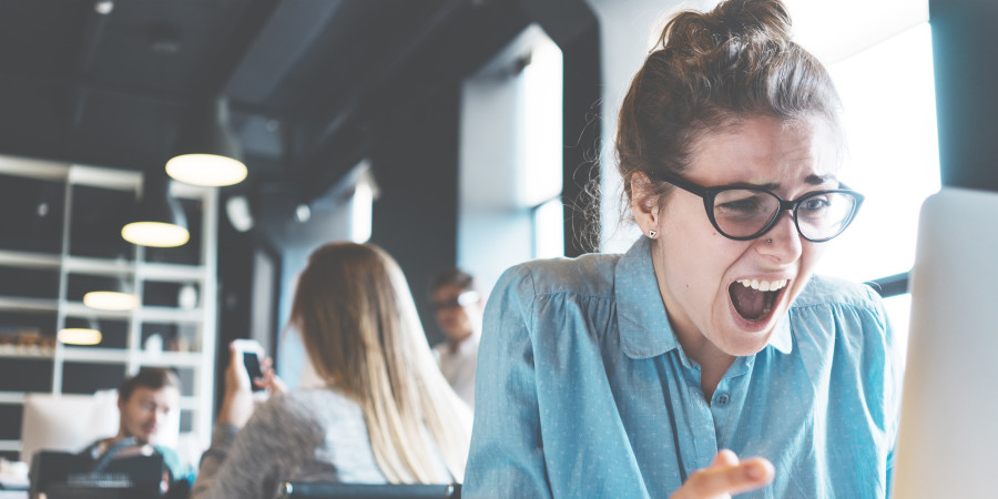 Une femme qui montre des signes de stress en utilisant son ordinateur.