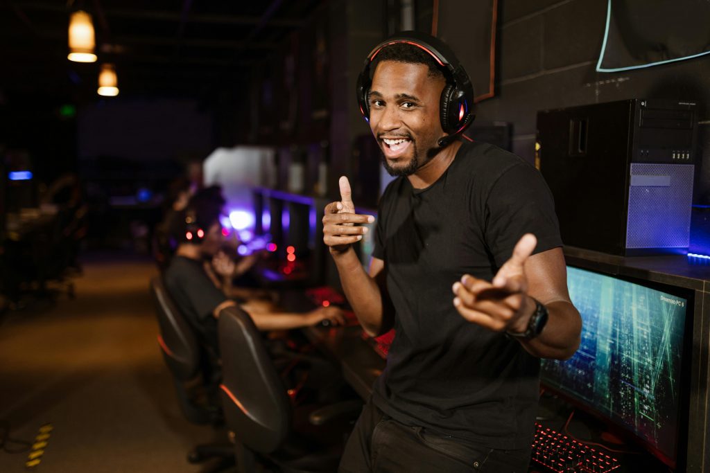 Un homme souriant portant un casque noir, écoutant de la musique de jeux vidéo.