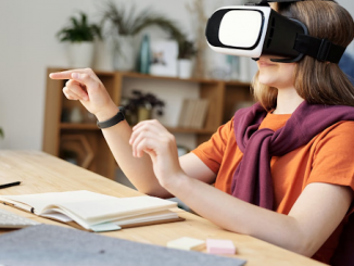 Une jeune fille portant des lunettes de réalité virtuelle avec un cahier et un stylo sur la table